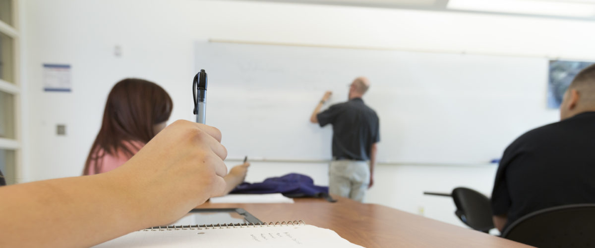 Student taking notes in a class