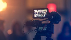 Video camera in dark room filming a wedding